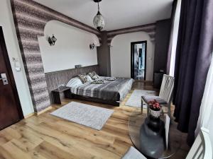 哈斯科沃Hotel Africa的一间卧室配有一张床,铺有木地板