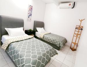 怡保SS Ipoh Comfort Homestay - For Families and Groups的两张睡床彼此相邻,位于一个房间里