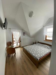 布伦纳Dom Nad Brennica的卧室配有1张床、1张桌子和1把椅子