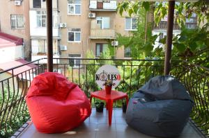 敖德萨hostel Koleso的阳台配有两个豆袋和红色桌子