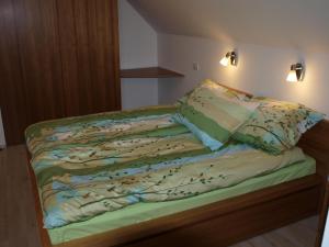 采尔克尼察克纳普公寓的一张带绿色床单和枕头的床