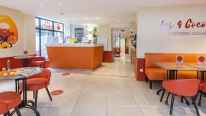 图卢兹奥尔斯布兰科中心酒店的一间设有橙色桌椅和柜台的餐厅