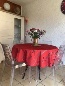 滨海阿热莱斯Mer Soleil Pinede的一张桌子,上面有红色的桌布,花瓶
