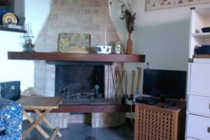 詹努特里岛Casa del pescatore Giannutri的客厅设有壁炉和电视。