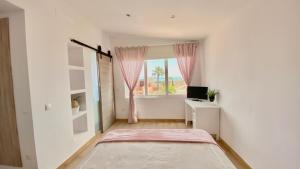 多列毛利诺斯Villa Ana María的白色的客房设有窗户、一张床和一张书桌