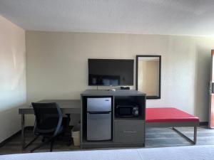 马里恩Dreamland Inn的客房设有书桌、红色长凳和电视。