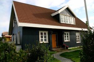 Stokkseyri赫巴民宿的一间黑色房子,屋顶为棕色