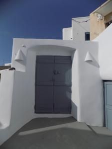 皮尔戈斯Imarkellis Santorini的白色的建筑,设有车库和两扇门