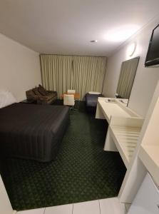 米尔迪拉卡顿伍德汽车旅馆的配有一张床和一张书桌的酒店客房