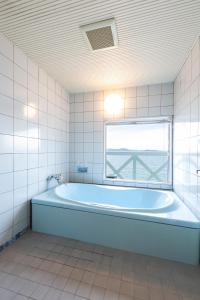 松山松山自由酒店（仅限成人） 的带浴缸的浴室和窗户