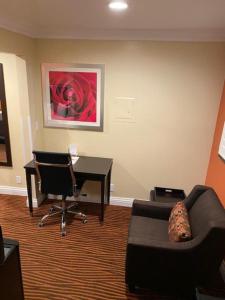 圣何塞会议中心汽车旅馆及套房的客厅配有书桌、沙发和椅子