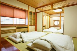 札幌Hostel PLEASURE MARUYAMA的带2扇窗户的客房内的2张床