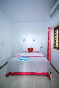 TuravūrMarari stella vich villa Homestay的白色卧室,配有一张红色椅子的床