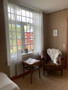 迪韦德Medstugans vandrarhem的一间卧室配有椅子、桌子和窗户