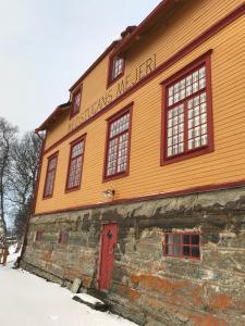迪韦德Medstugans vandrarhem的一座橙色的建筑,雪中有一扇红色门