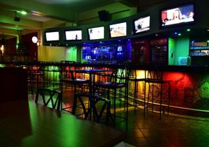 埃尔多雷特Klique Hotel Eldoret的一间酒吧,里面设有凳子和电视