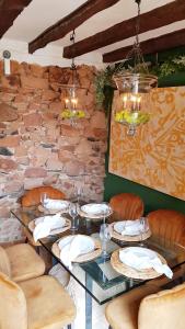 巴尼奥斯德莱恩西纳玛丽亚罗莎宅邸酒店的餐厅的一张桌子,有石墙