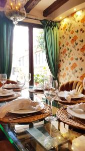 巴尼奥斯德莱恩西纳玛丽亚罗莎宅邸酒店的用餐室配有带盘子和酒杯的桌子