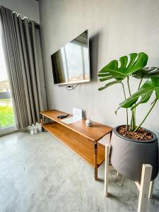 尖竹汶贝蒂加斯姆赤达布瑞旅馆的一间设有书桌和盆栽的房间