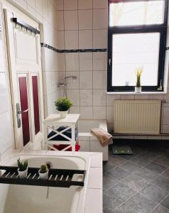 瓦尔斯罗德Ferienwohnung Eddelhoff的一间带水槽和浴缸的浴室以及窗户。