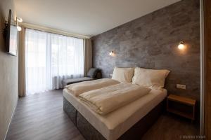 波切尼斯Apartmány I - KAfe Bojnice的一间卧室设有一张带砖墙的大床