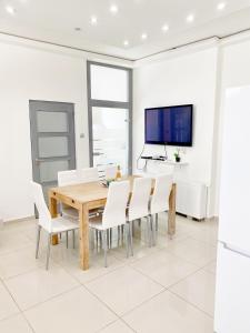 布达佩斯LUXURY apartment in the centre with a place for barbecue party的一间带木桌和白色椅子的用餐室