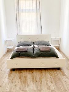 布达佩斯LUXURY apartment in the centre with a place for barbecue party的卧室铺有木地板,配有一张白色的床。