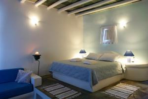 Áno MeriáAnatoli的一间卧室配有一张床和一张蓝色的沙发