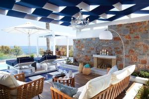莫拉托斯Minos Imperial Luxury Beach Resort & Spa Milatos的客厅设有蓝色的天花板和壁炉。