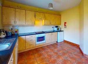 邓莫尔东Seacliff HH No 8的厨房配有木制橱柜和瓷砖地板。