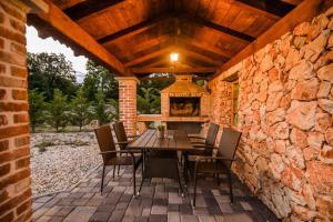 克拉斯Villa Plasa Krk的石头墙上的庭院配有木桌和椅子
