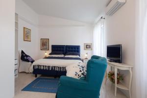 蒙特罗索阿尔马雷Come Eravamo的一间卧室配有一张床和一张蓝色椅子