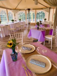 内米勒格洛特农家乐的配有桌椅和紫色桌布的帐篷
