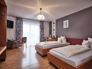 巴特塞京根阿姆霍汗天高饭店的酒店客房设有两张床、一张桌子和一张书桌。