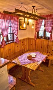 奥托亚克Vineyard cottage Podržaj的一间设有桌子和红色及白色窗帘的用餐室