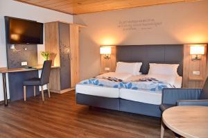 诺德林根Cafe-Hotel Altreuter的酒店客房带一张床、一张桌子和椅子