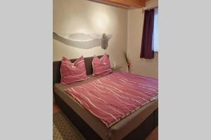 巴特戈特洛伊巴Quartier am Markt- Ferienwohnung的一间卧室配有一张带粉色床单和枕头的床。