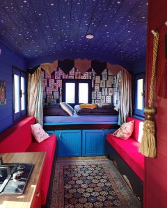 BeaulonLa roulotte MAGIC ! des Grillots的一间设有两张床和厨房的火车室