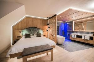 布鲁尼科Majestic Hotel & Spa Resort的一间卧室设有一张大床和一个浴缸
