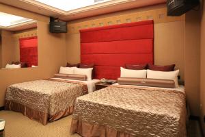 台北印石时尚旅馆的酒店客房设有两张床和红色床头板
