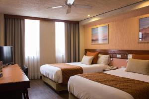墨西哥城Hotel Marlowe Centro Histórico的酒店客房配有两张床和一张书桌