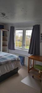 邓弗姆林Homely Haven, Dunfermline的卧室配有一张床、一张书桌和窗户。