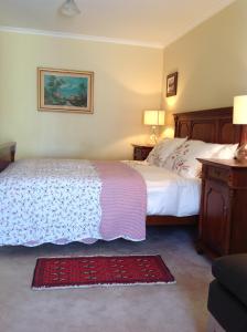 堪培拉库克度假屋的一间卧室配有两张床、两盏灯和地毯。