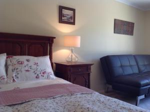 堪培拉库克度假屋的一间卧室配有一张床和一张蓝色椅子