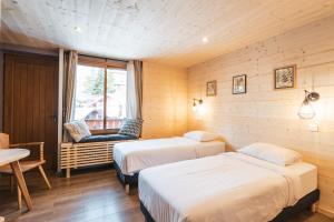 莱德萨阿尔卑斯Hotel Les Lutins的一间设有两张床和椅子的房间