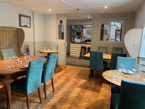 利德福德The Dartmoor Inn at Lydford的餐厅设有木桌和蓝色椅子