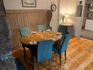 利德福德The Dartmoor Inn at Lydford的一间带桌椅和时钟的用餐室