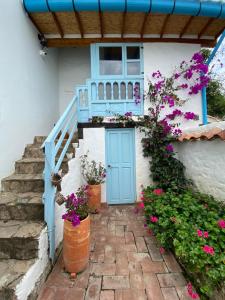 莱瓦镇Hotel Casa Boutique Villa de Leyva的一座带蓝色门和一些花的房屋