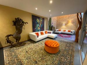 普拉亚卡门Casarte Boutique Hotel的客厅配有白色沙发和橙色凳子