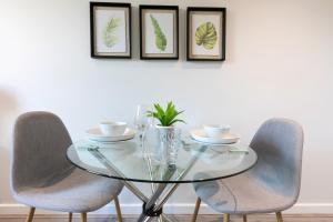 普雷斯顿City Haven Preston Apartments的一张玻璃餐桌,配有两把椅子和三张框图